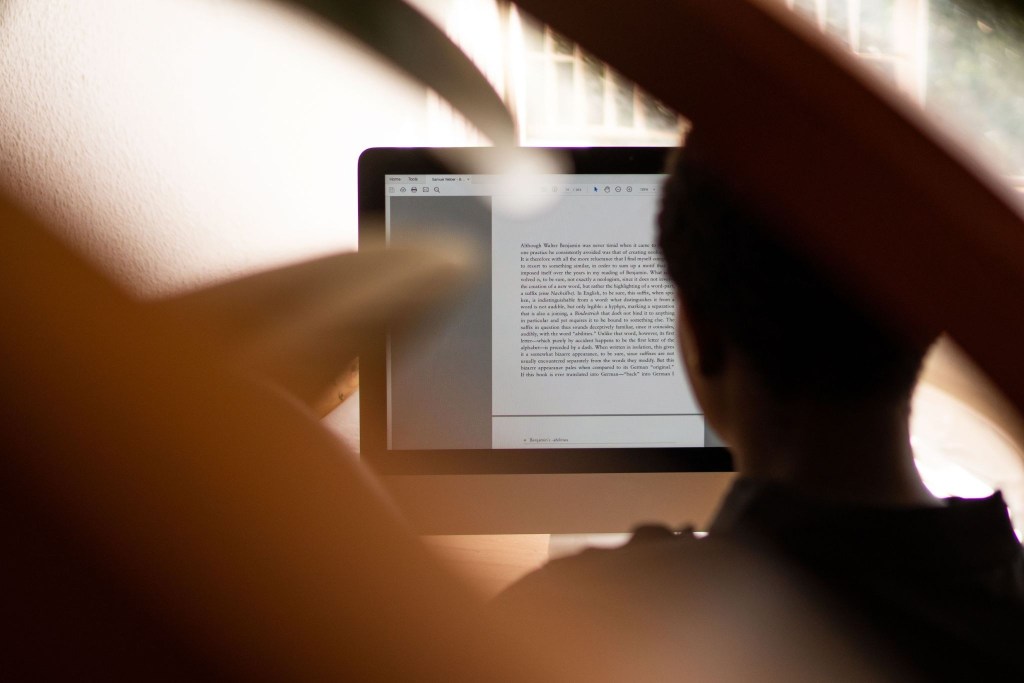 A person working on a piece of writing, indicating their unique human voice, another example of why AI will not replace writers