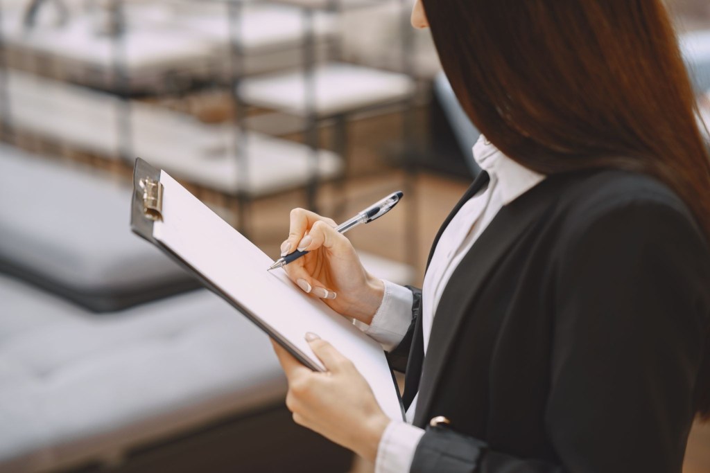 A woman holding clipboard, perhaps applying for a freelance copywriting and proofreading job