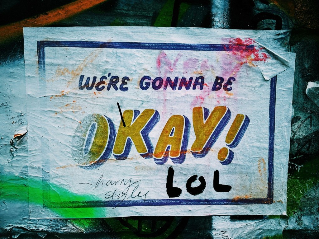 A colorful but dirty printed sign that says, "We're Gonna Be Okay. LOL"