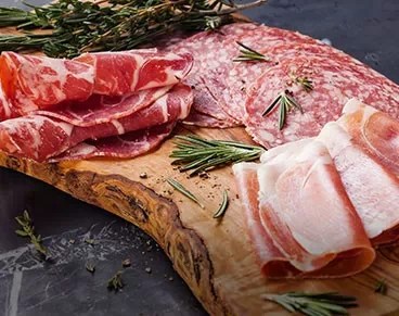 Selection of cold cuts served on a rustic wood platter