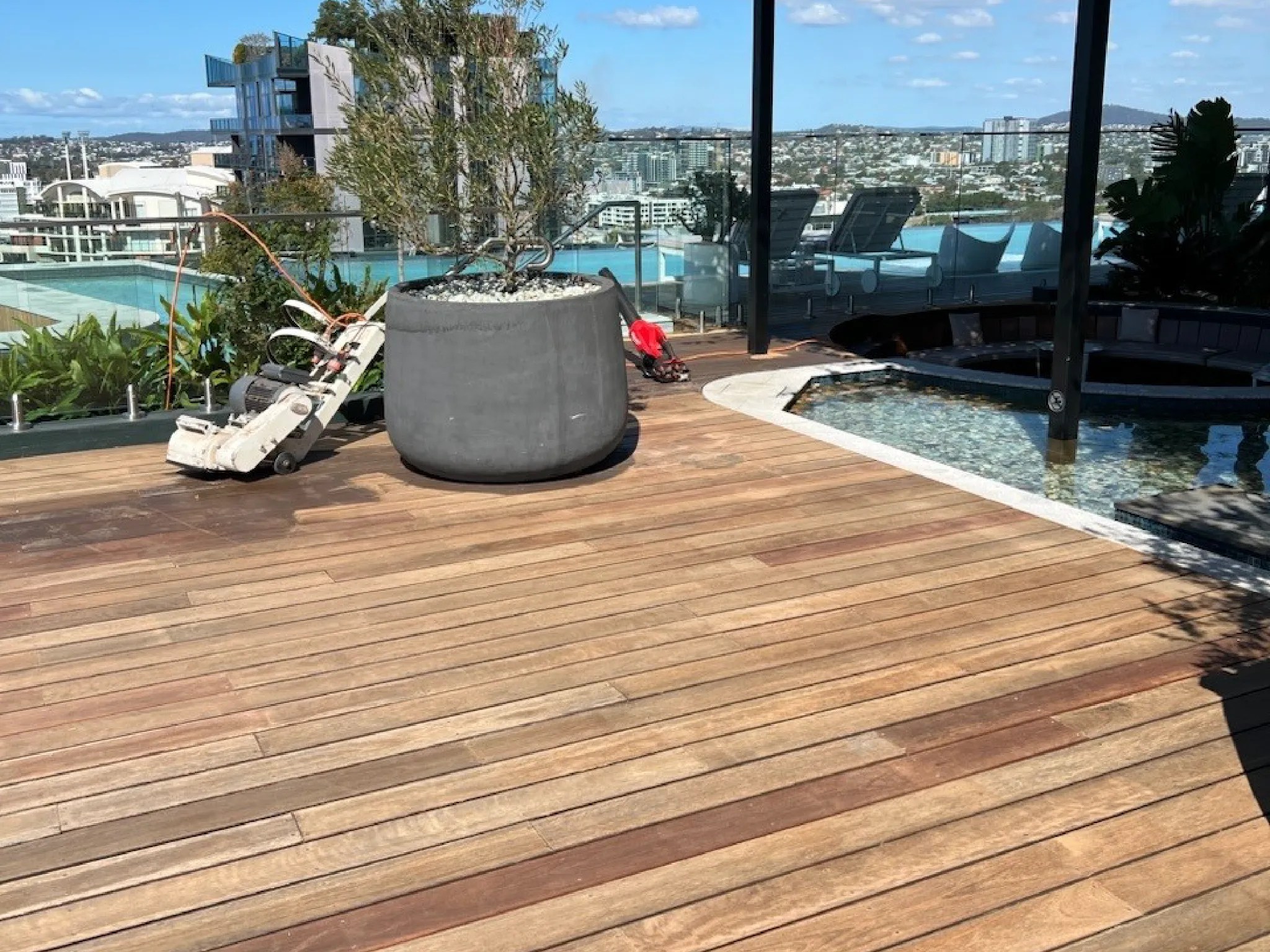Rooftop deck featuring wooden flooring, a large planter, and a small pool area.