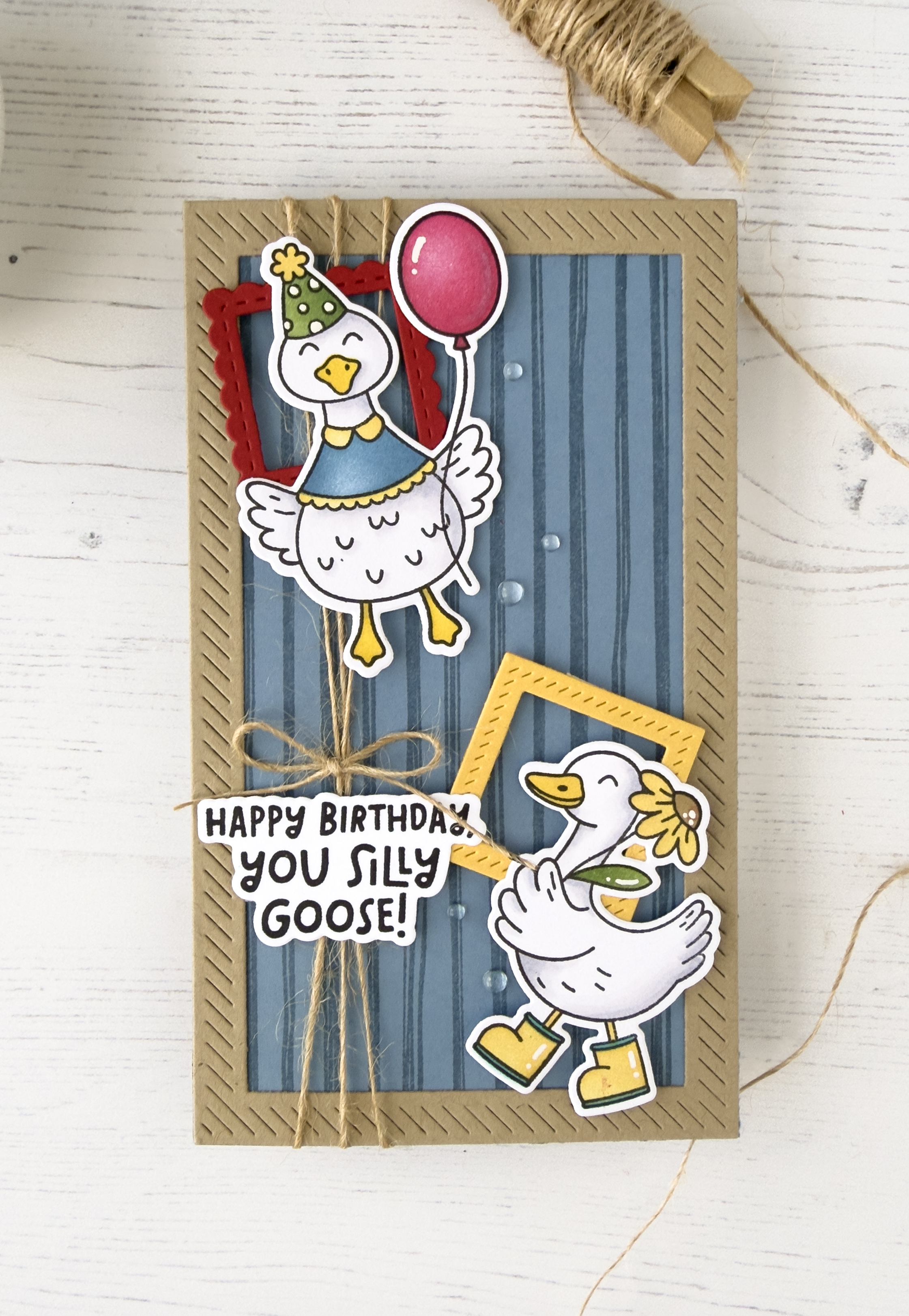 A handmade card with two geese on the front. One goose holds a red balloon and the other holds a yellow flower. The sentiment says Happy Birthday You Silly Goose.