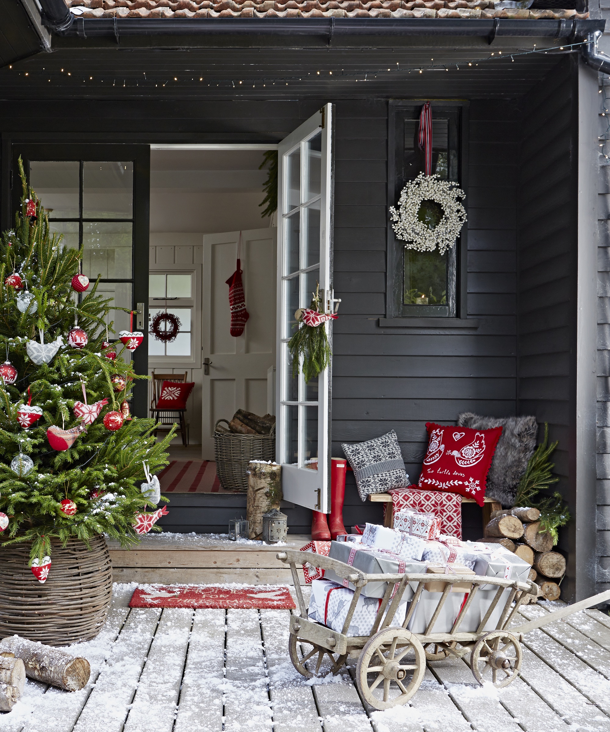 Exterior, black weatherboard wooden house, courtyard, wood floorboards, decking, Christmas tree, willow basket, toy wooden wagon / cart with presents, open door into hallway, cushions, CH&I 12/2013