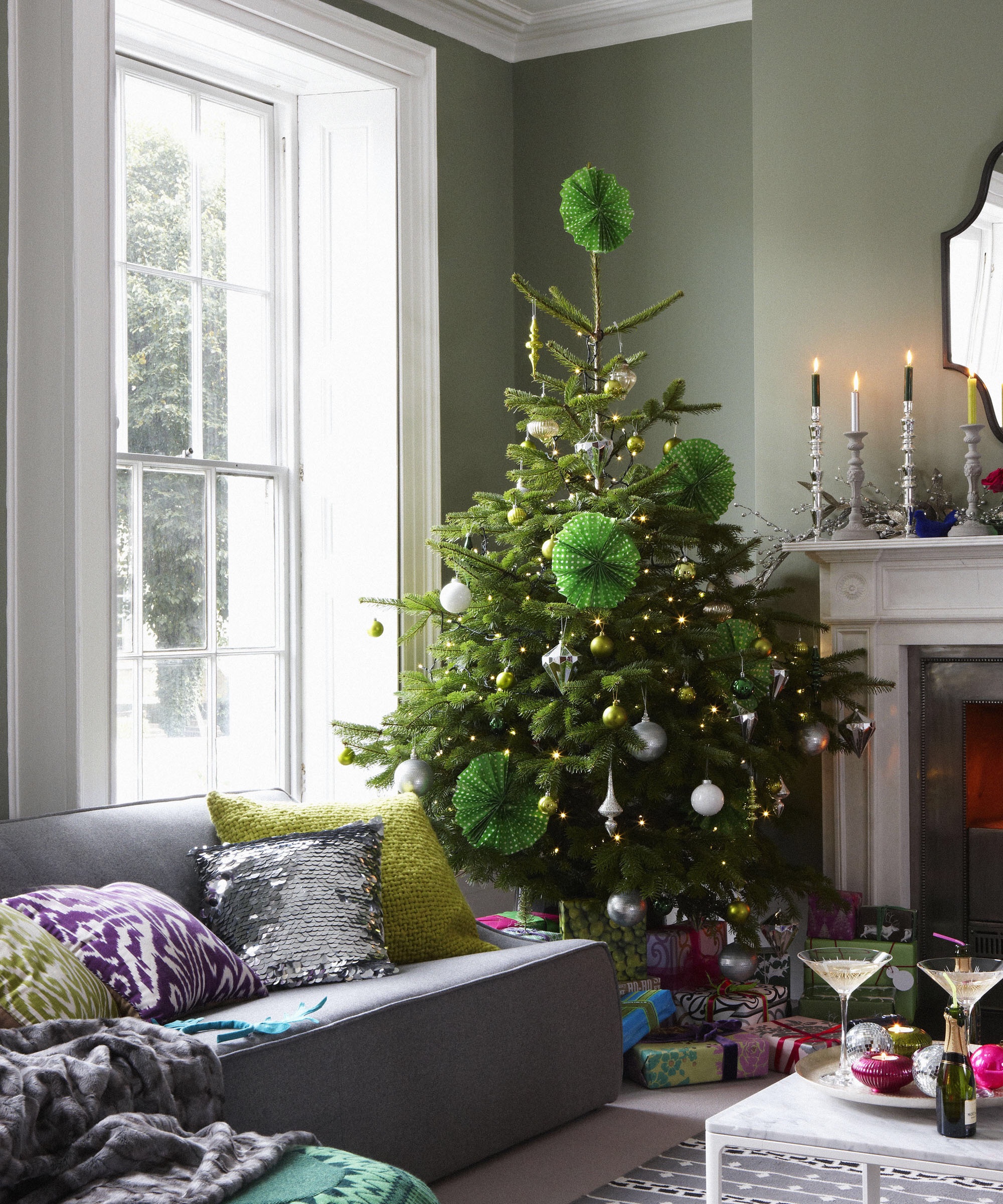 Grey living room sofa assorted cushions natural Christmas tree presents sash window, fireplace coffee table with mini champagne bottles and martini glasses, candlestick on mantelpiece L etc 12/2009 not used
