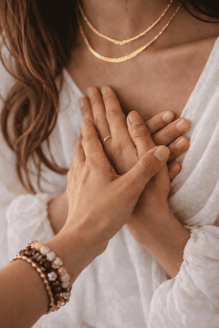 Woman holding her heart with hands – mind healing and emotional wellness retreat Bali