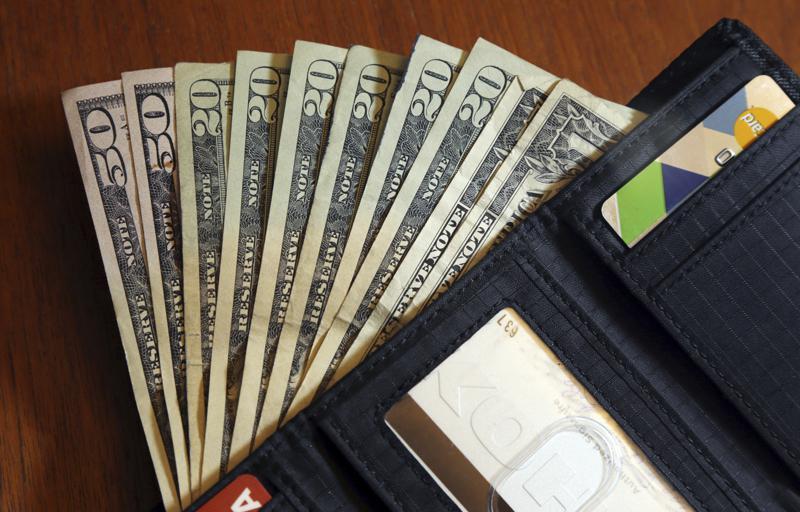 FILE - In this June 15, 2018, file photo, cash is fanned out from a wallet in North Andover, Mass. Following a family budget is challenging, especially when unexpected costs pop up, including those related to the high prices at the grocery store and rising interest rates. Financial experts say you can overcome those obstacles by creating a flexible approach to managing your money. Start by tracking your spending, leaving room for some unplanned expenses and cutting back where you can, especially on food and travel.