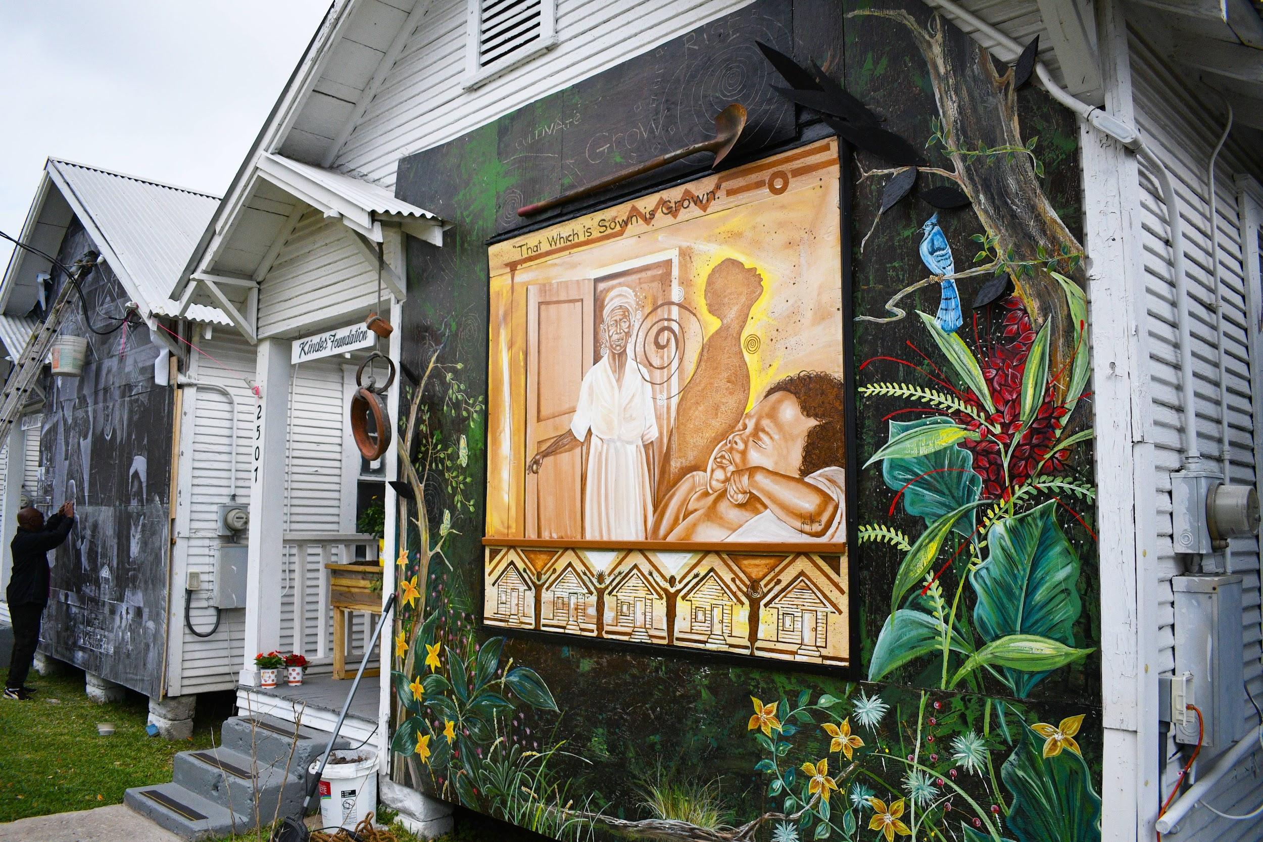 Artist Israel McCloud’s white row house featuring a mural on the front called ‘House Being Home as Garden.’