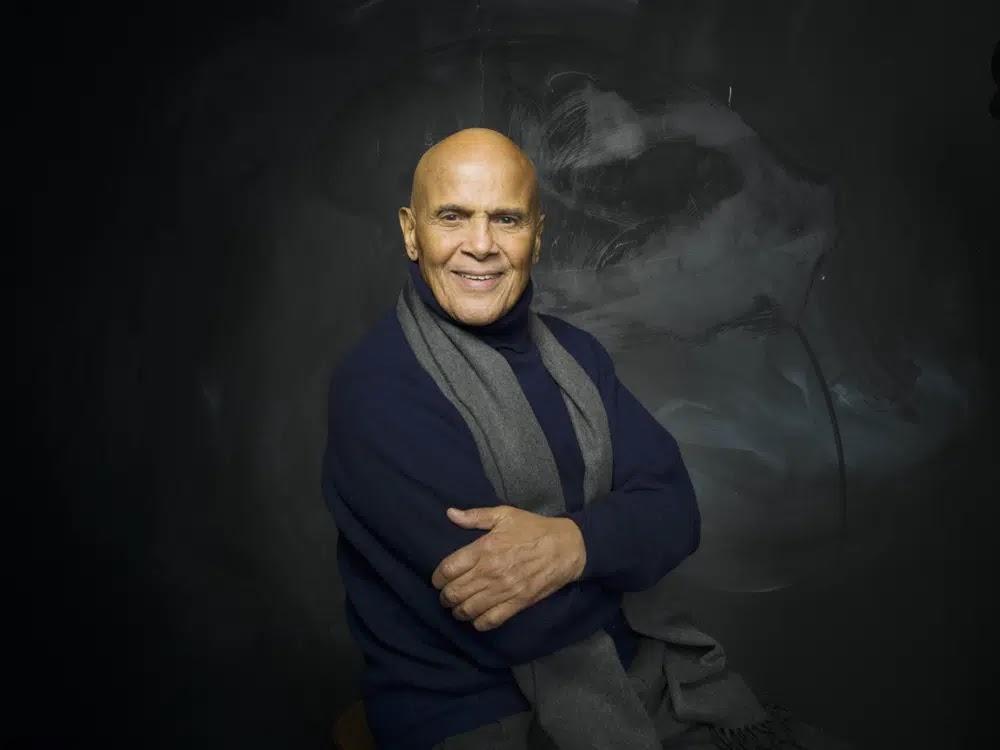 Actor, singer and activist Harry Belafonte poses for a portrait during the Sundance Film Festival in 2011; he is dressed in a dark top and scarf against a black backround