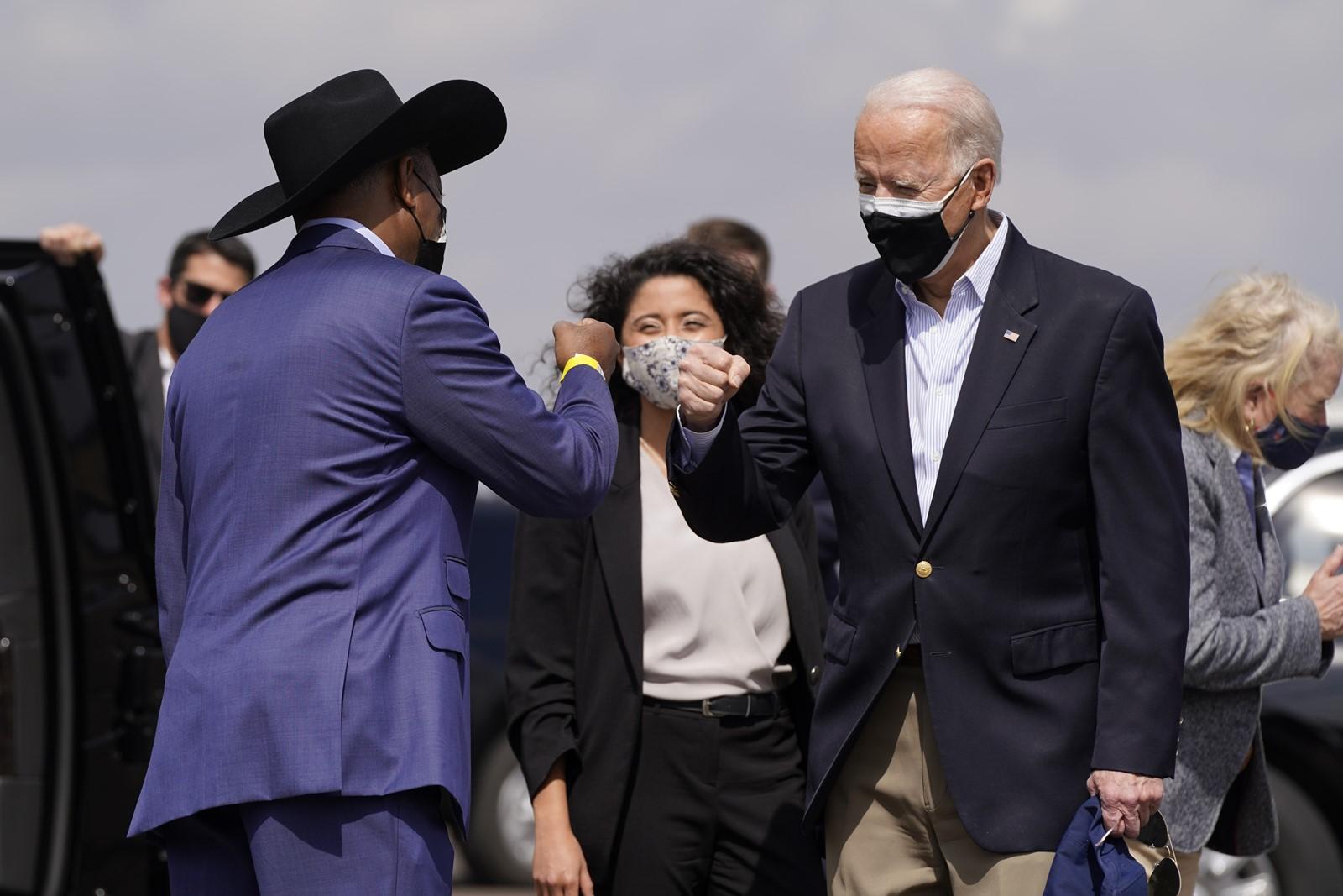 Houston Mayor Sylvester Turner and President Joe Biden, both masked, greet each other with a fist bump