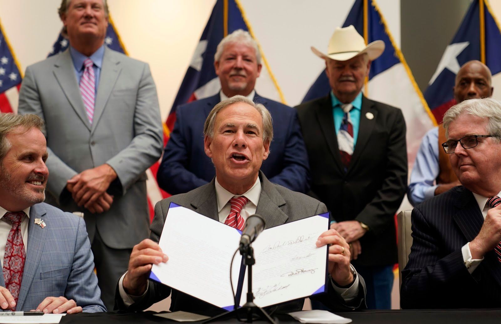 Texas Gov Greg Abbott (center) smiles after signing the 2021 ‘election integrity bill’