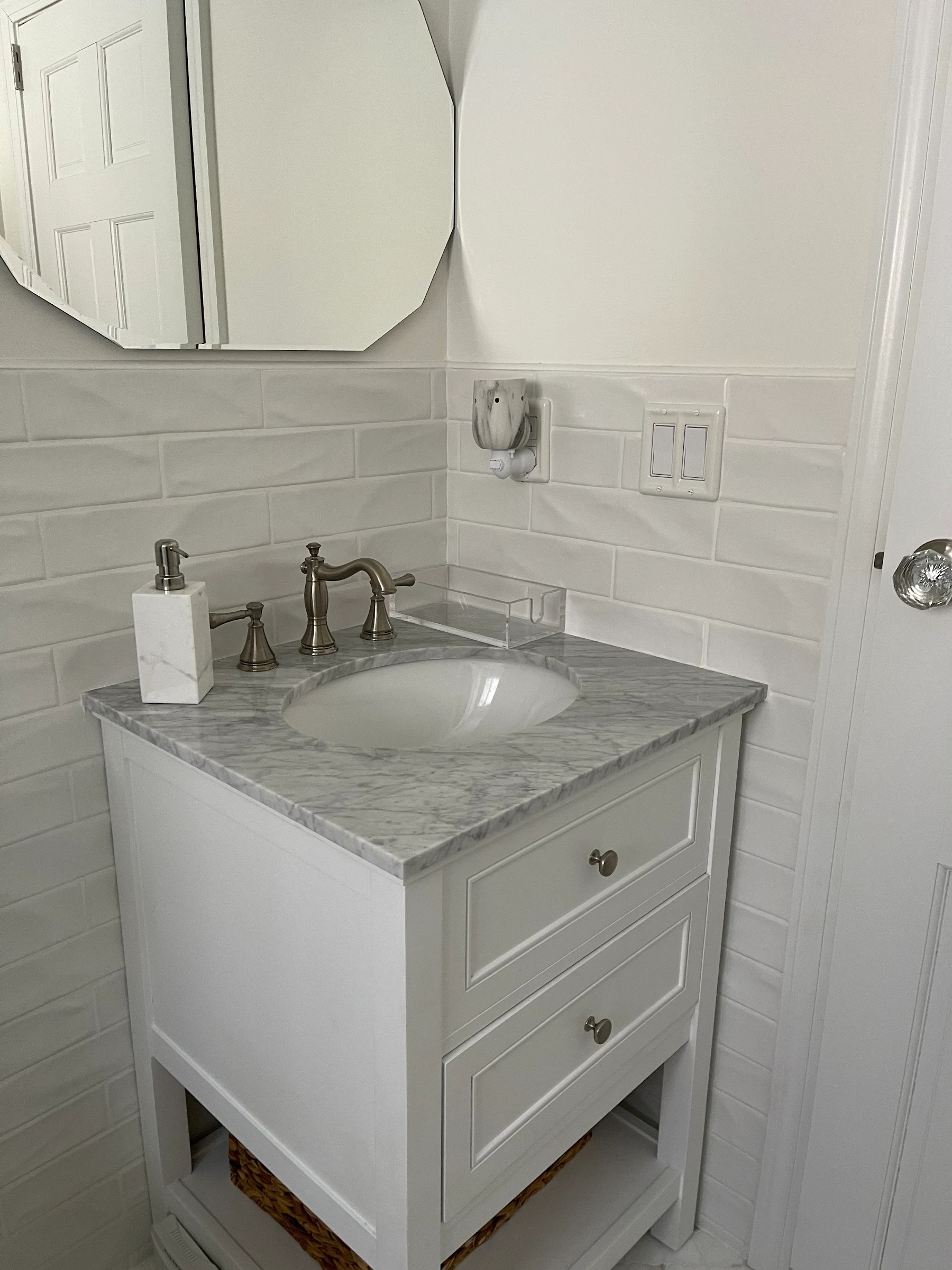 White bathroom vanity with marble-look top, sink, and brushed-metal faucet