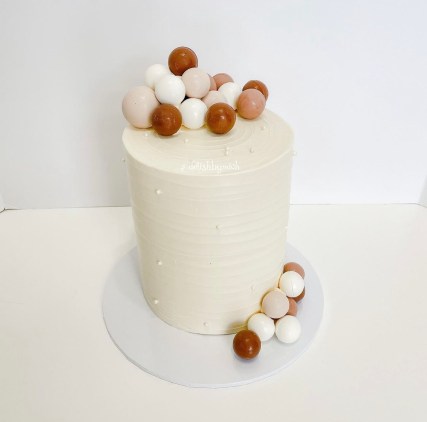 6” double barrel cake with white chocolate, dark chocolate and caramel spheres