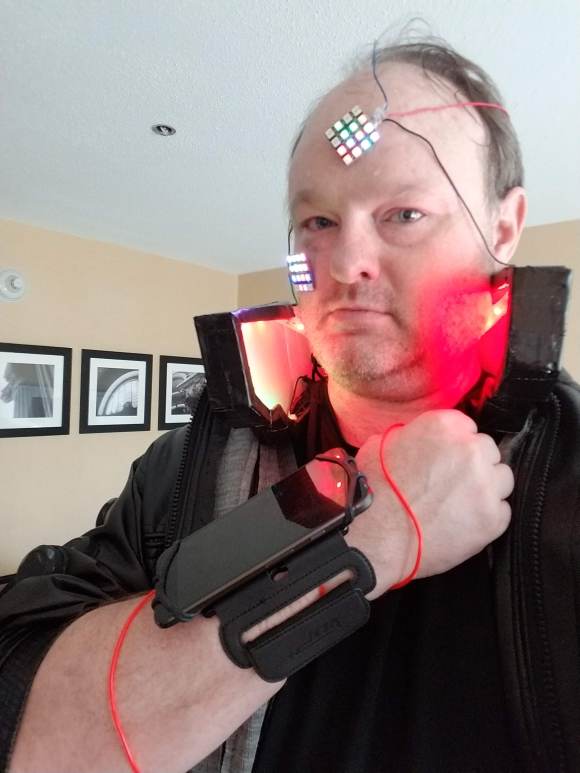 Wrist mounted smartphone, light up collar, LEDs glued to my face, and el wire on my arm. Not pictured is the bluetooth keyboard on my other wrist.