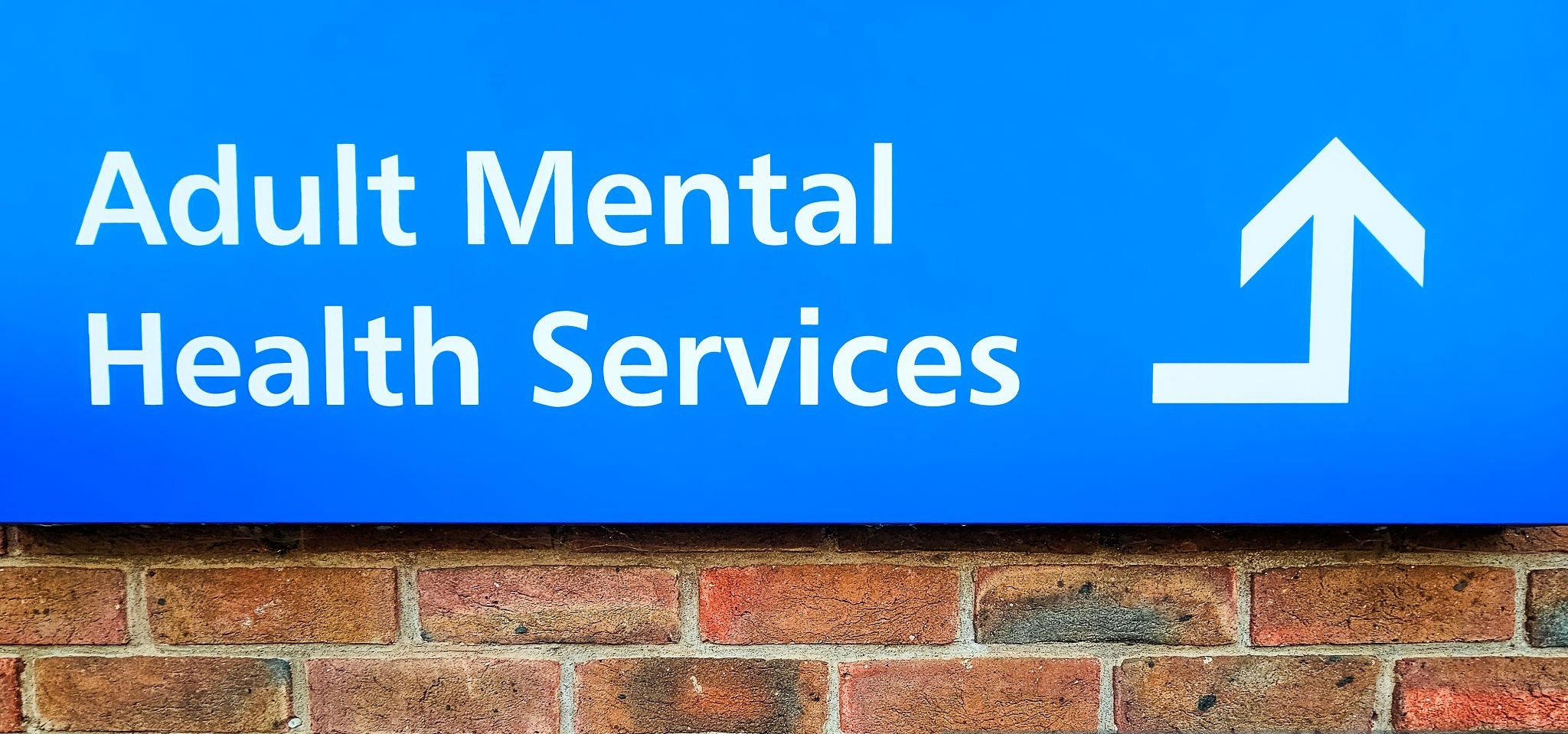 A sign saying 'Adult Mental Health Services' outside a support facility.