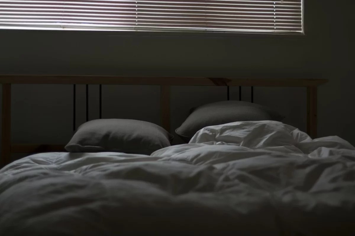 Cama destendida con almohadas