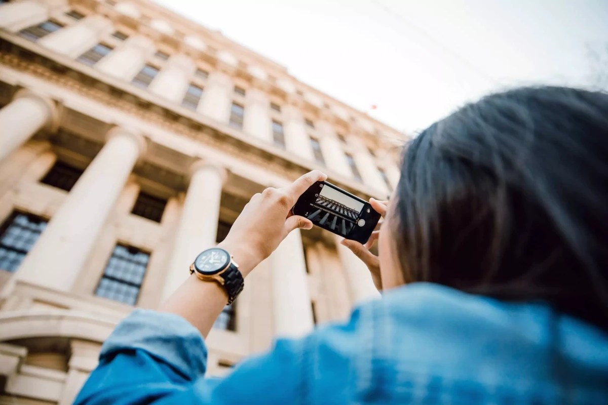 Girl taking photo of a building for art course