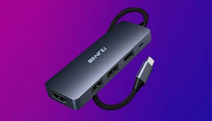 Setup de designer com hub USB conectado a laptop, monitor 4K e tablet gráfico