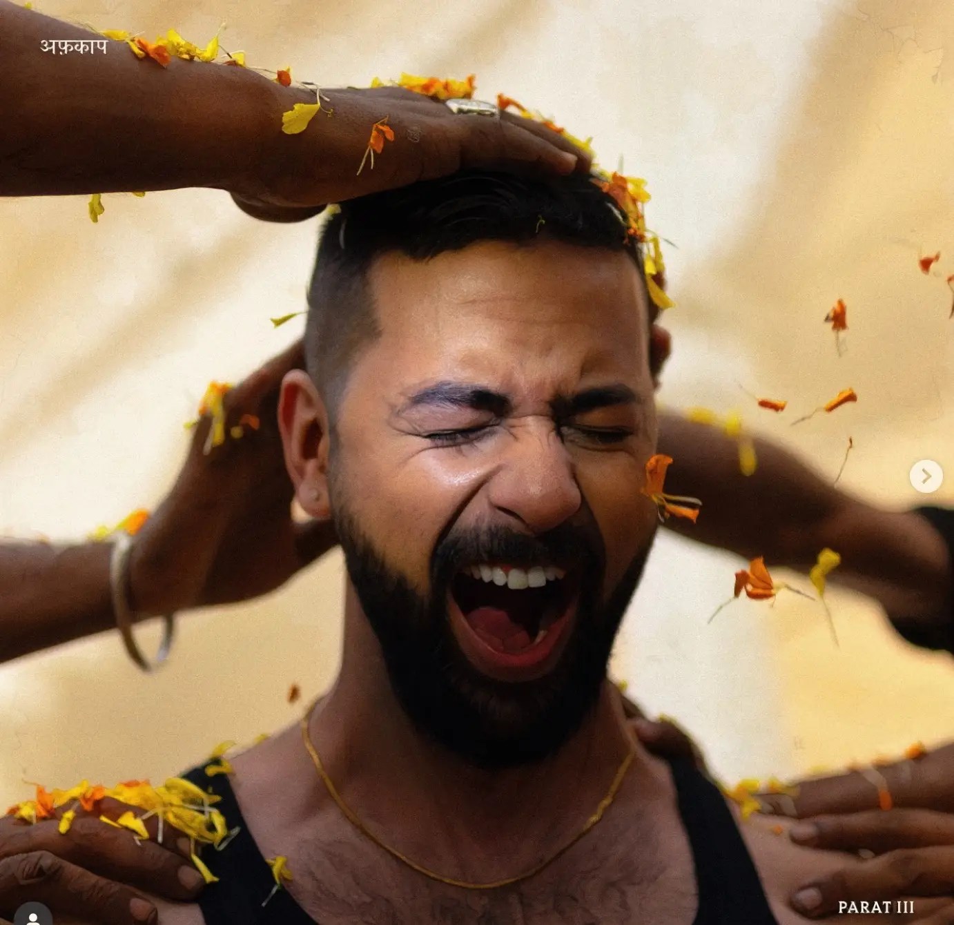 Afkap on the cover of Parat 3, eyes closed in catharsis as marigold petals fall and hands bless him, symbolising renewal and responsibility.