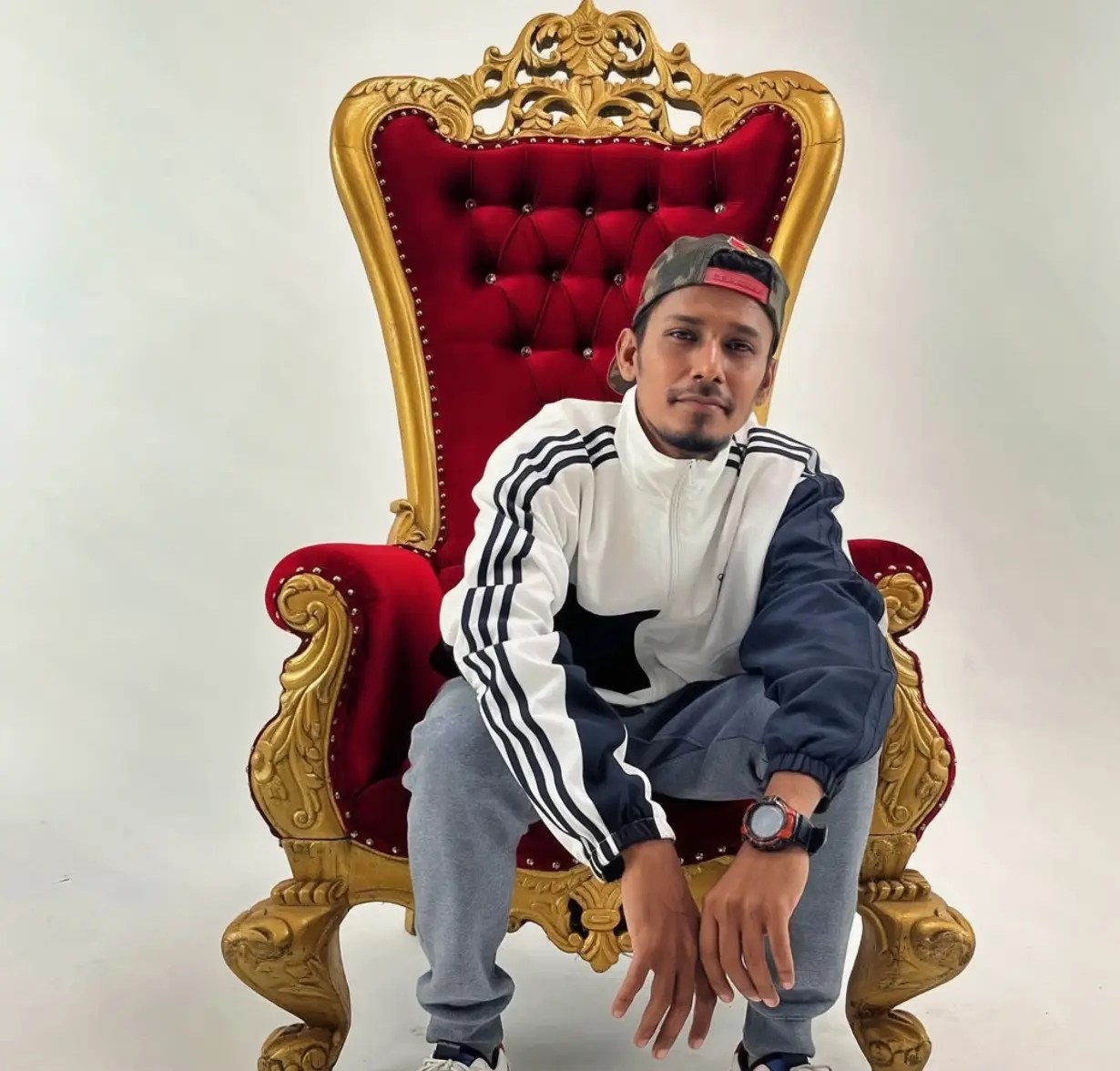 Neerajomatic, Mumbai hip hop artist, sitting on a red and gold throne chair during his 2025 interview with Desi Renaissance about Realest and his journey in Desi Hip Hop.