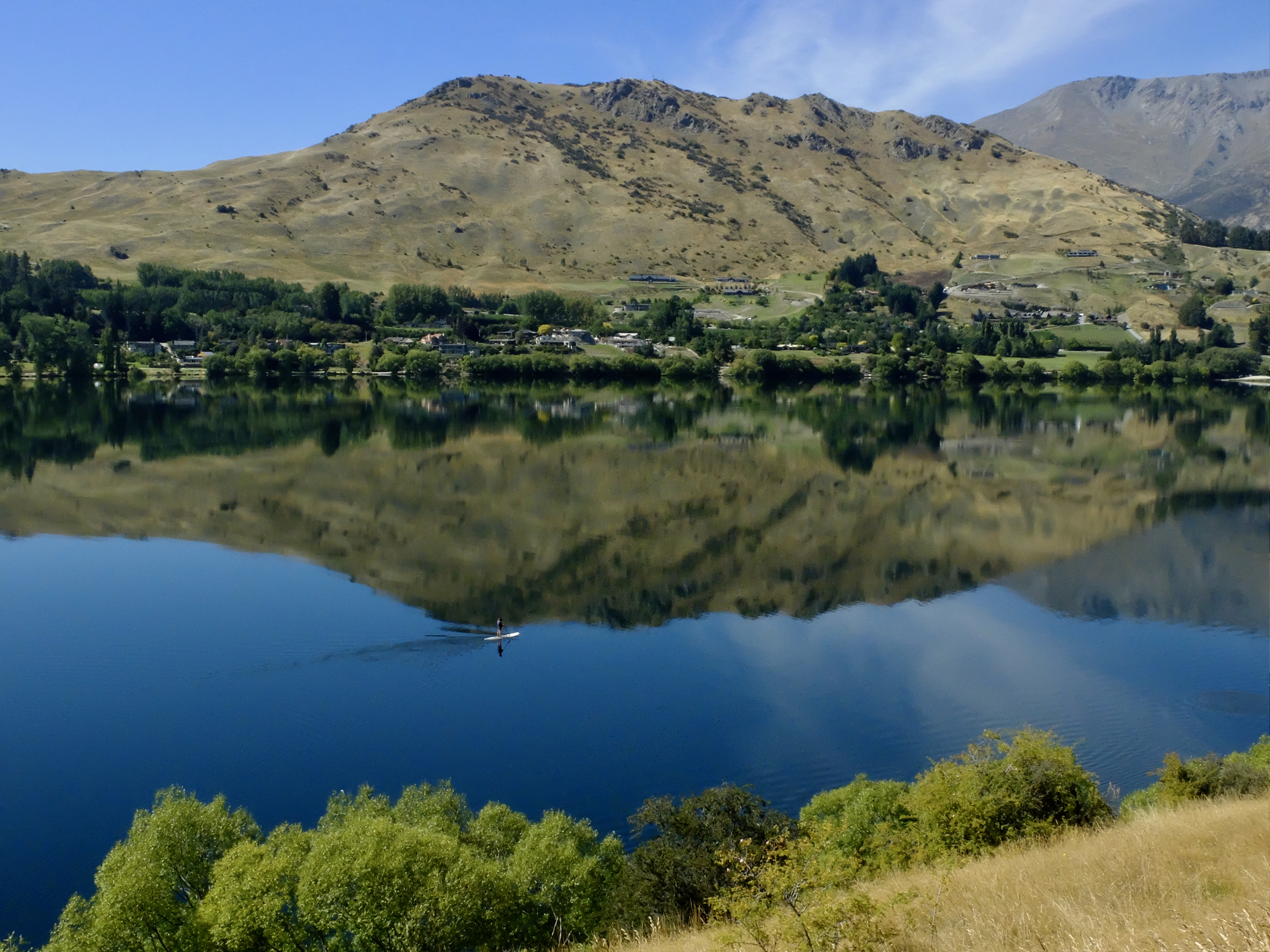 A paddle boarder breaks the reflection - Lake Hayes, NZ