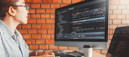 young woman viewing computer code on screen