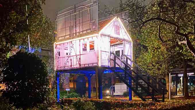 Witte hut op blauwe palen in groene omgeving