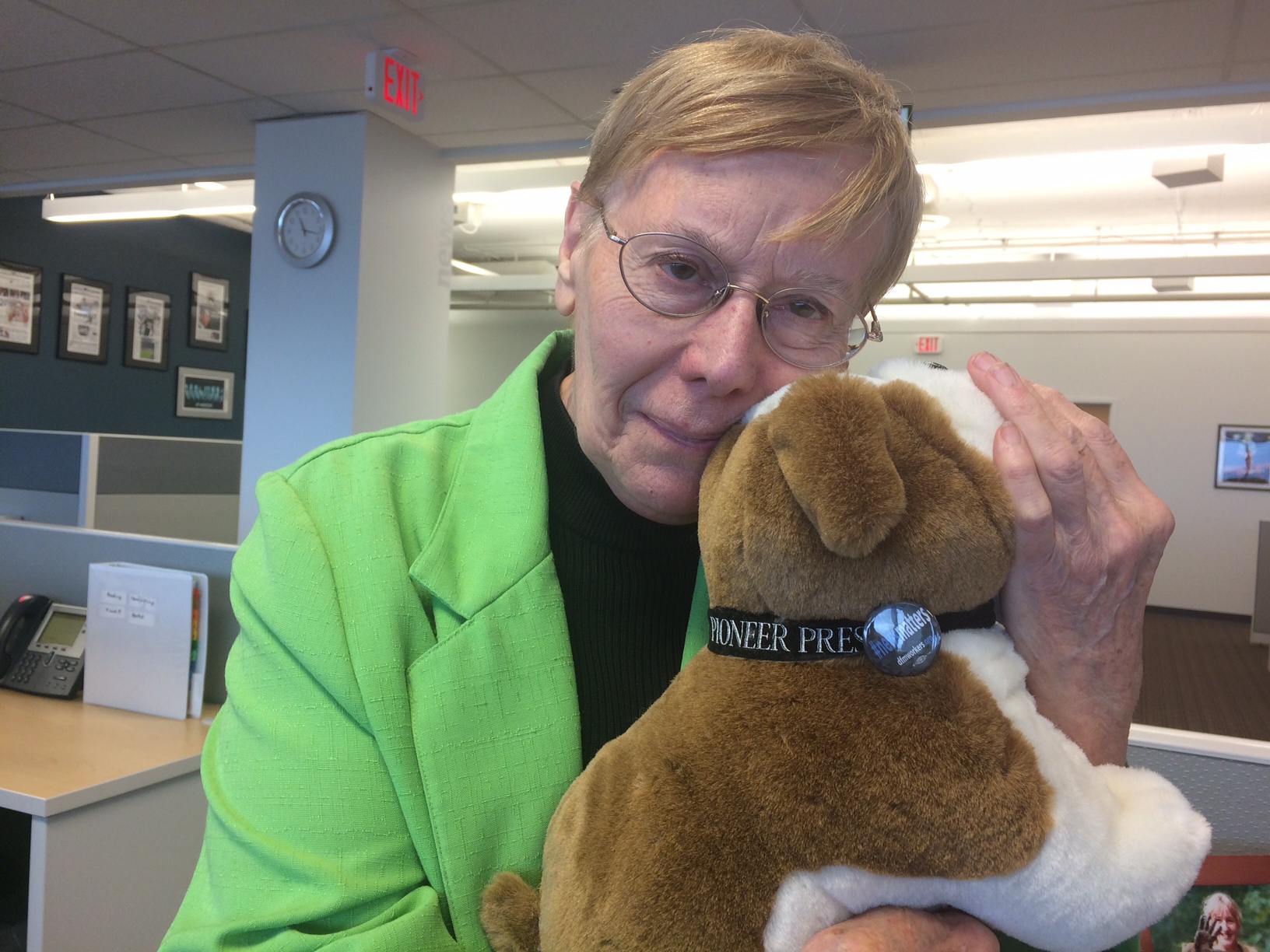 Mary Ann Grossmann, a Pioneer Press newsroom employee since 1961, cuddles a bulldog, the paper's mascot. Pooches know #newsmatters.