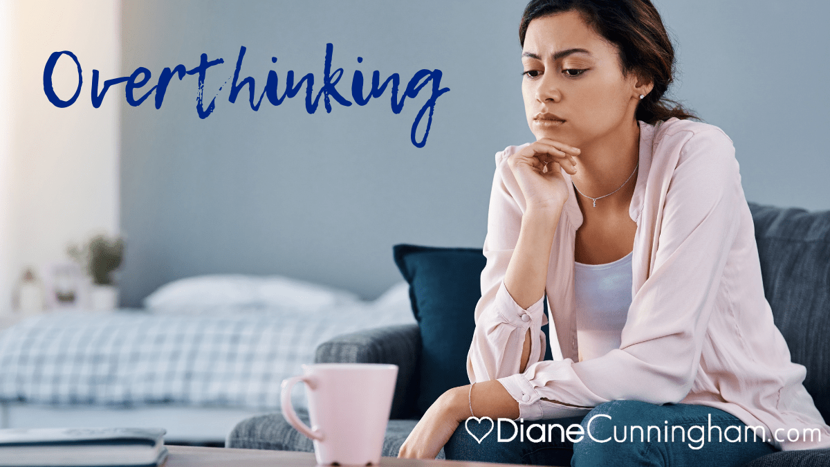 overthinking, woman sitting on sofa with a beverage looking confused and pensive