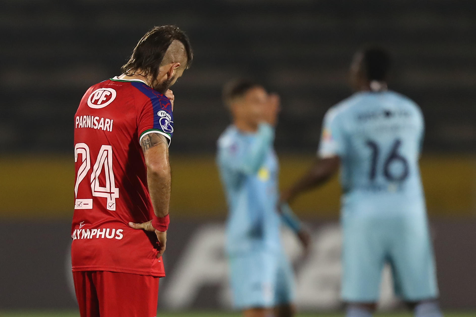 El defensor argentino Ezequiel Parnisari (i)  lamenta la derrota de Unión La Calera por 4-0 este jueves en su visita a Universidad de Quito para el partido de la cuarta jornada de la fase de grupos de la Copa Libertadores jugado en el estadio Olímpico Atahualpa en Quito. EFE/ José Jácome
