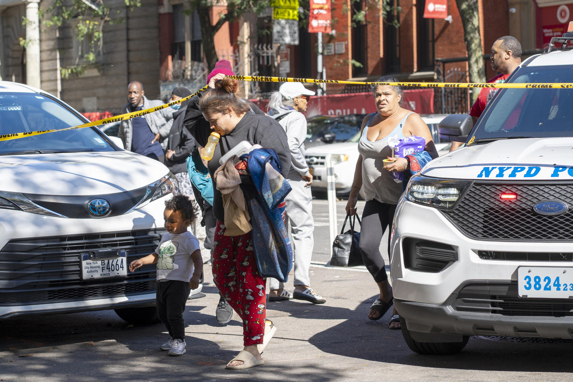 Personas caminan por una zona custodiada luego del derrumbe parcial de un edificio este miércoles, en el distrito de El Bronx en Nueva York (Estados Unidos). EFE/ Ángel Colmenares

