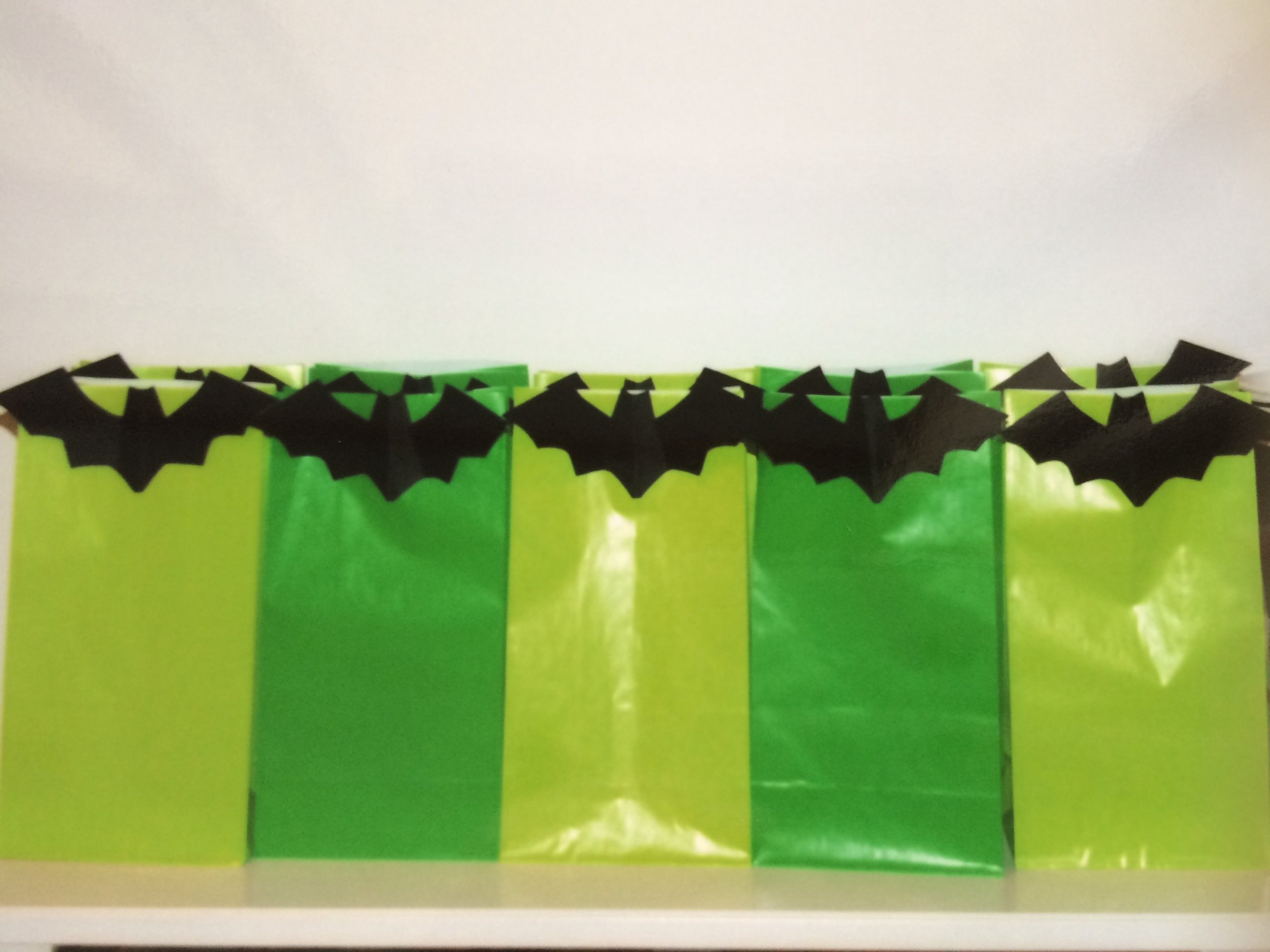 Green Halloween party - green trick or treat loot bags with black bat on each