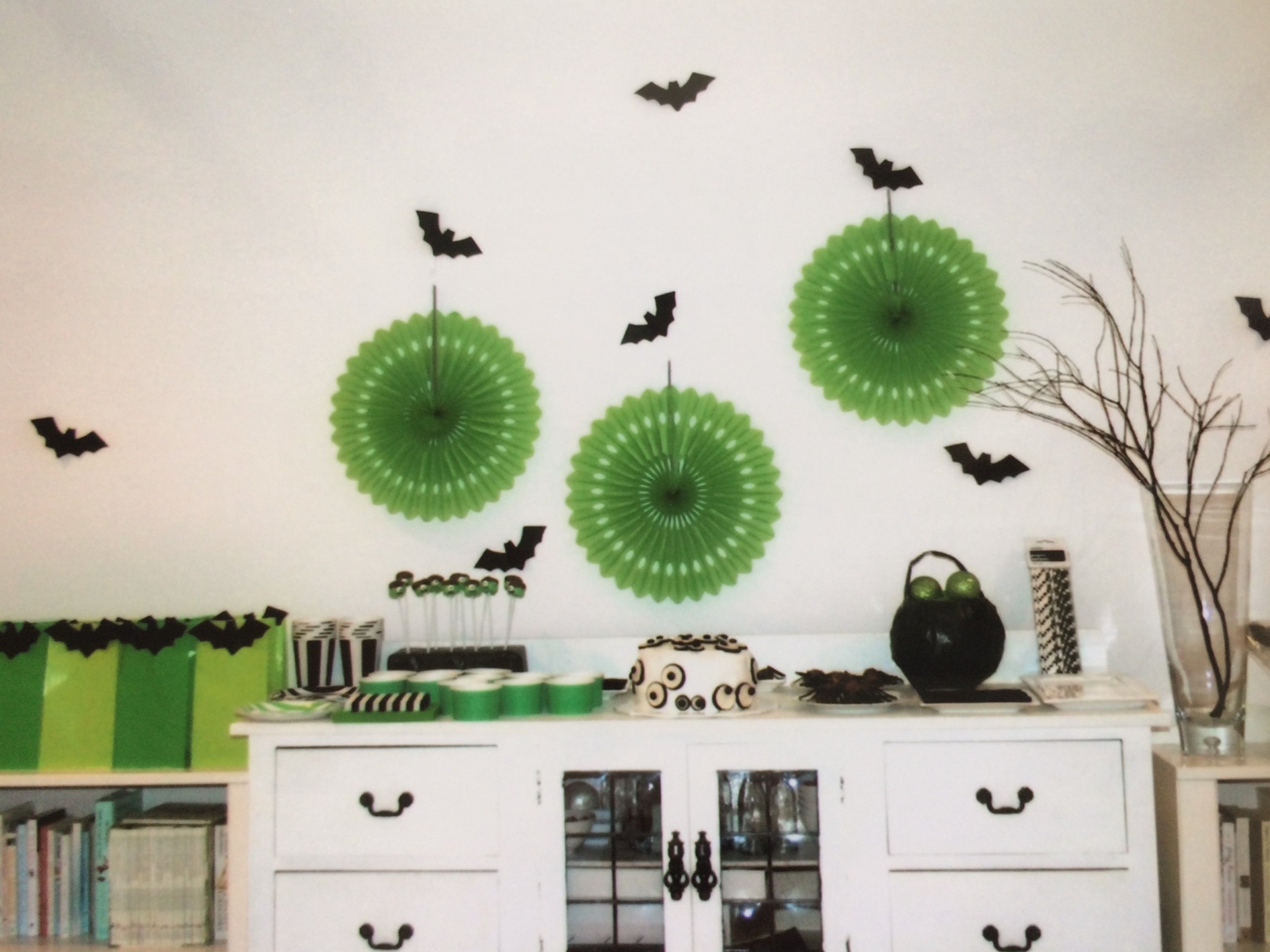 Halloween backdrop and dessert table with black bats, green decorations and party bags