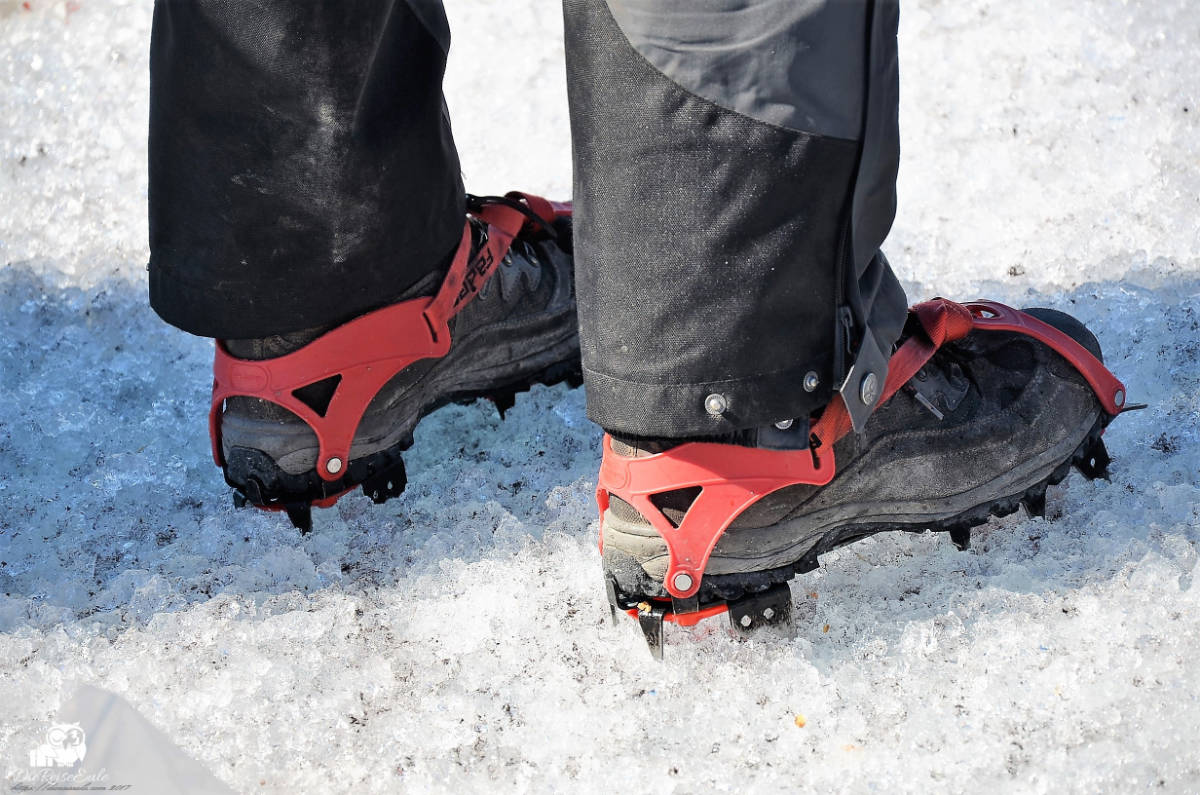 steigeisen an schuhen, person steht auf grönländischem inlandeis