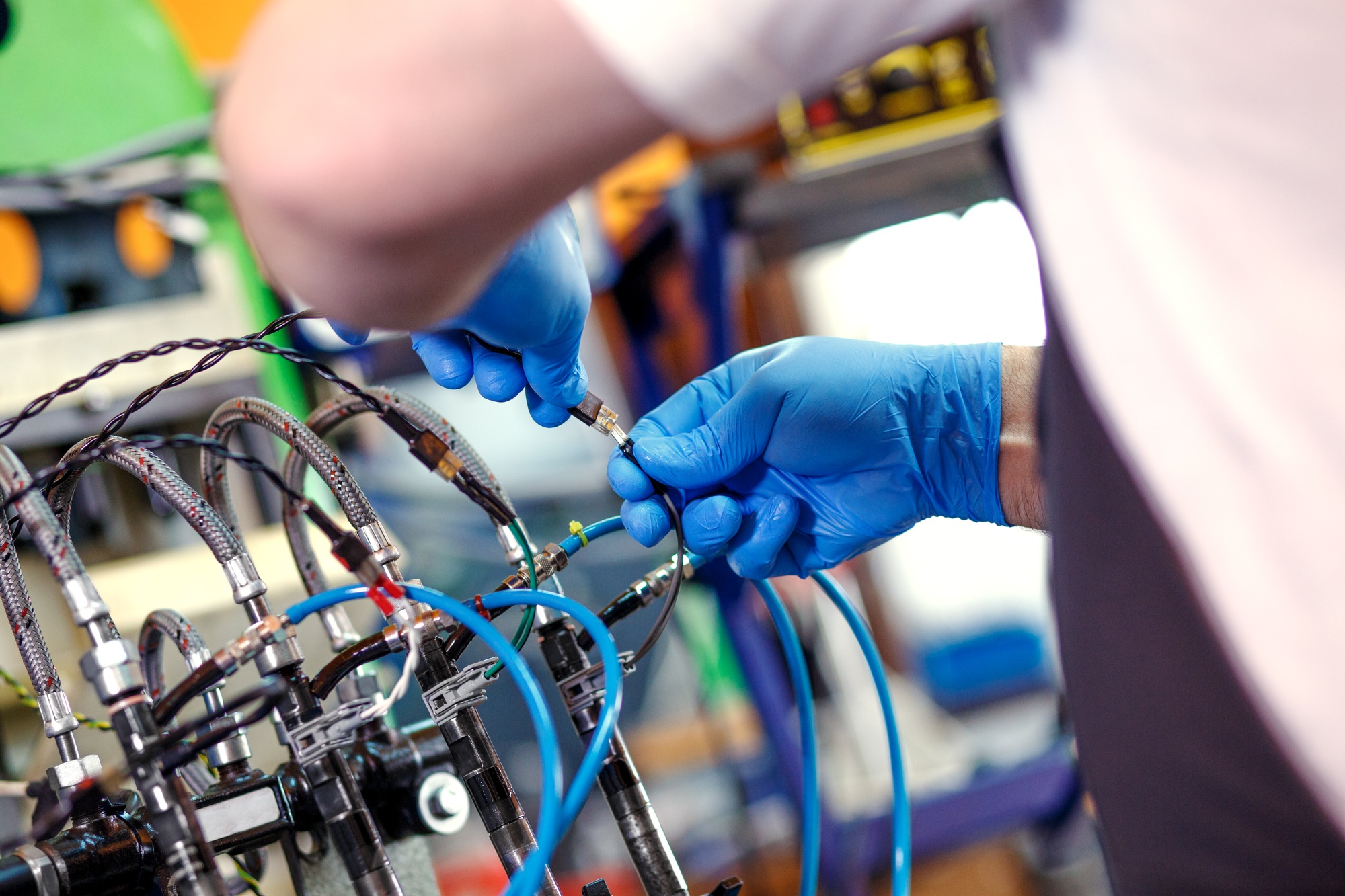 Professional mechanic testing diesel injector in his workshop.