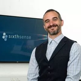 Man smiling in front of a display screen