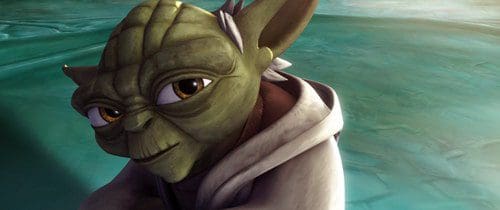 A close-up of a wise green alien with large eyes and pointed ears, wearing a light robe. The character is set against a serene, blurred background that suggests a mystical location.