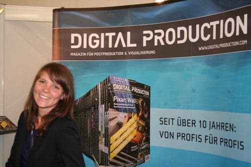 A smiling woman in a black blazer stands in front of a colorful display showcasing digital production magazines, including a feature on Pixar. The background includes a blue design with text in German.