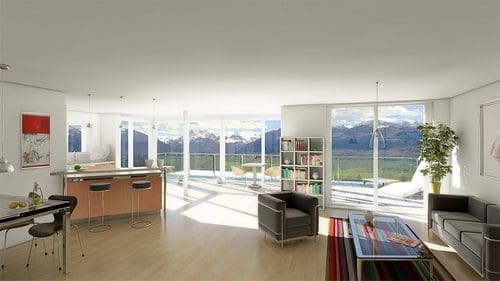 A modern living room with large windows offering a panoramic view of mountains. The open space features a small kitchen with bar stools, a cozy seating area with black chairs, and a decorative bookshelf beside a potted plant.