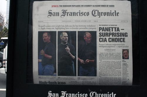 A newspaper front page of the San Francisco Chronicle featuring a headline about Steve Jobs alongside four images of him speaking. The article discusses Apple and its leadership. Additional sports news at the top of the page.