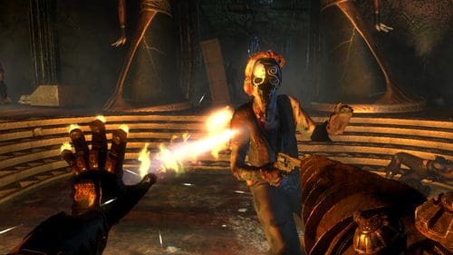 A character in a fierce battle scene is aiming a glowing weapon at an approaching enemy, who is wearing a mask and appears to be on fire. The environment is dark, with ancient statues looming in the background.