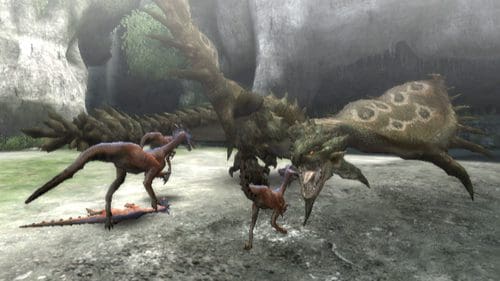 A scene featuring three dinosaur-like creatures in a natural setting. Two smaller, feathered dinosaurs stand on the left, while a larger, scaly creature with distinct patterns looms on the right. The environment includes rugged stone walls and greenery in the background.