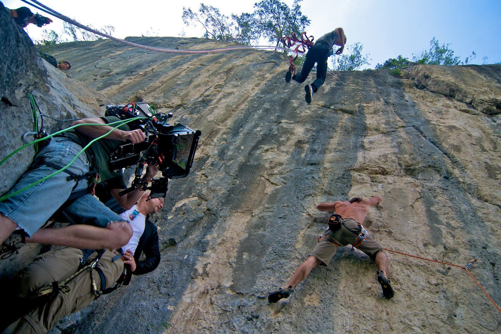 Filmmakers capturing rock climbing scene on a cliff