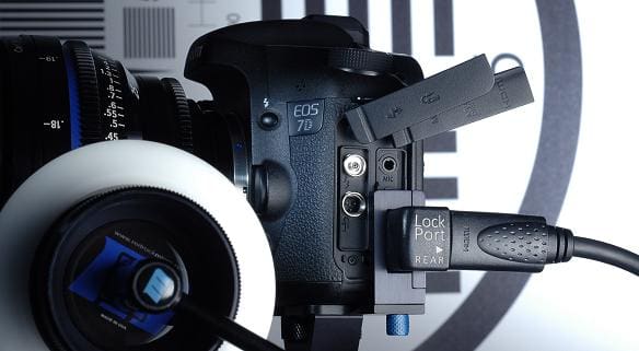 A Canon EOS 7D camera with attached cables and a focus ring