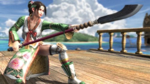 A female warrior wearing a colorful traditional outfit and armor poses dramatically with a curved weapon on a wooden platform, overlooking a tropical landscape with blue skies and clouds.