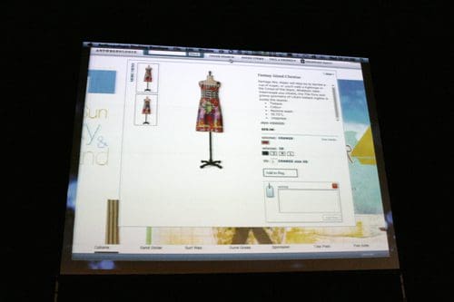 A digital display showing an online shopping interface featuring a colorful dress on a mannequin. The dress has a vibrant pattern, and details about the item, including size options and product description, are visible on the screen.
