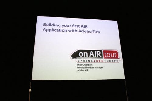 A presentation slide displaying the title 'Building your first AIR Application with Adobe Flex.' Below the title is the logo of the 'on AIR tour Spring 2008 Europe' and the presenter’s name, Mike Chambers, Principal Product Manager at Adobe AIR.