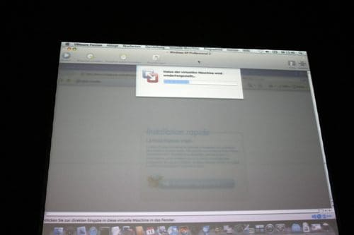 A computer screen displaying a software installation process with a progress bar and a notification message. The background is slightly blurred, and the taskbar is visible at the bottom, typical of a Mac interface.