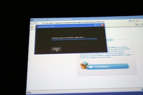 A computer screen displaying a web browser with a dialog box that reads "Getting ready to install the application." A visible button labeled "Cancel" is highlighted in the center of the dialog box.