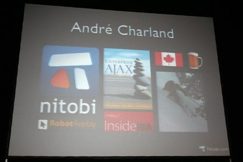A presentation slide featuring the name "André Charland" prominently at the top. Below, there are various icons and images including the Nitobi logo, a book titled "Enterprise AJAX," a Canadian flag, a beer mug, and a photograph of a woman reclining.