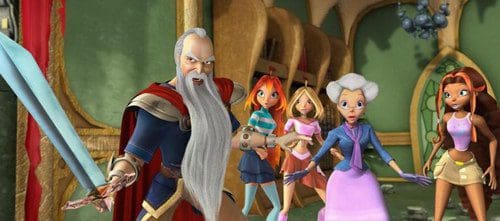 A group of animated characters in a whimsical setting. A wise, older man with a long beard brandishes a sword confidently, flanked by four young women in colorful outfits, displaying expressions of surprise and determination.